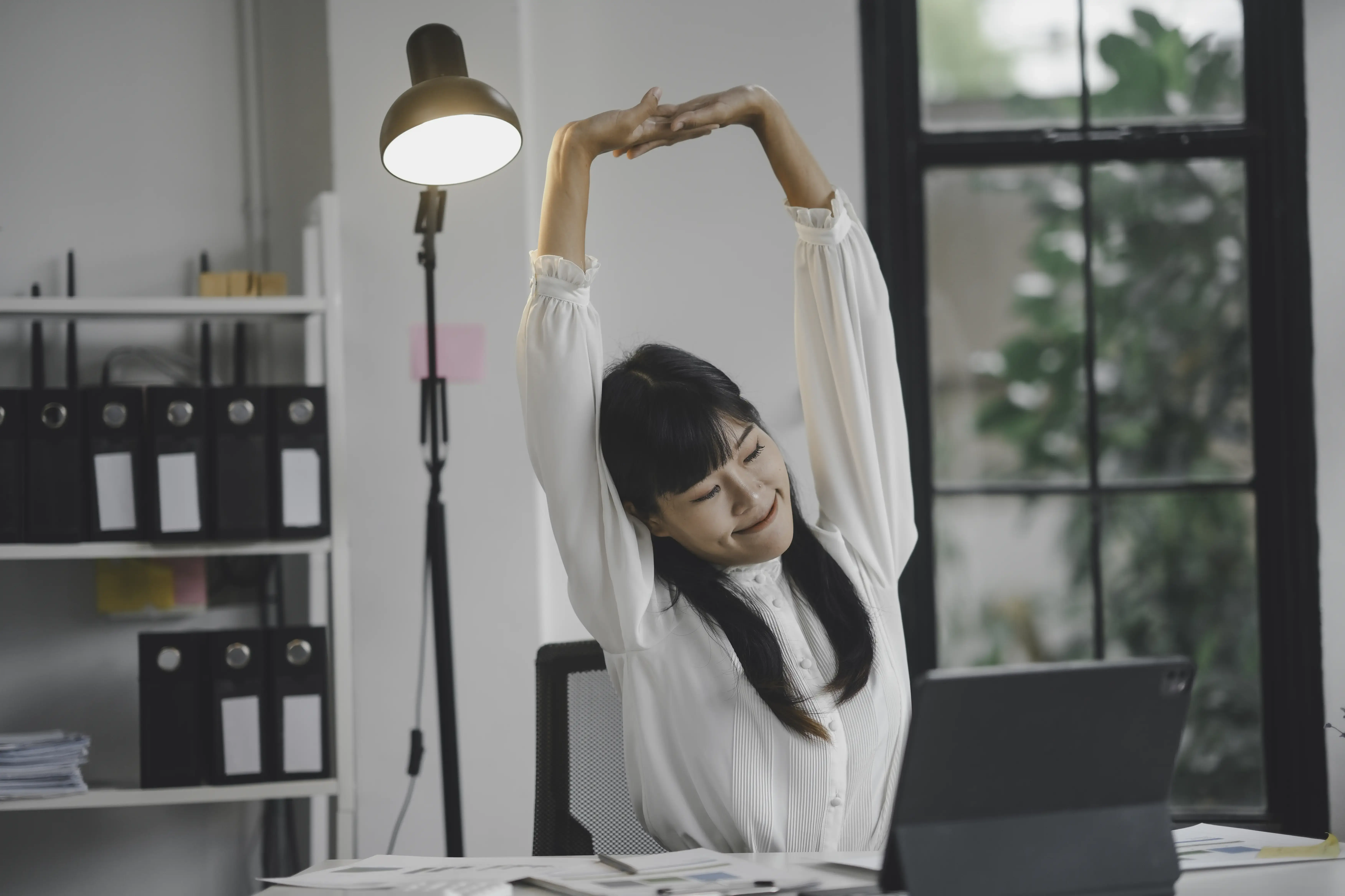 asian-businesswoman-stretching-arms-while-working-2025-03-08-08-35-01-utc.webp