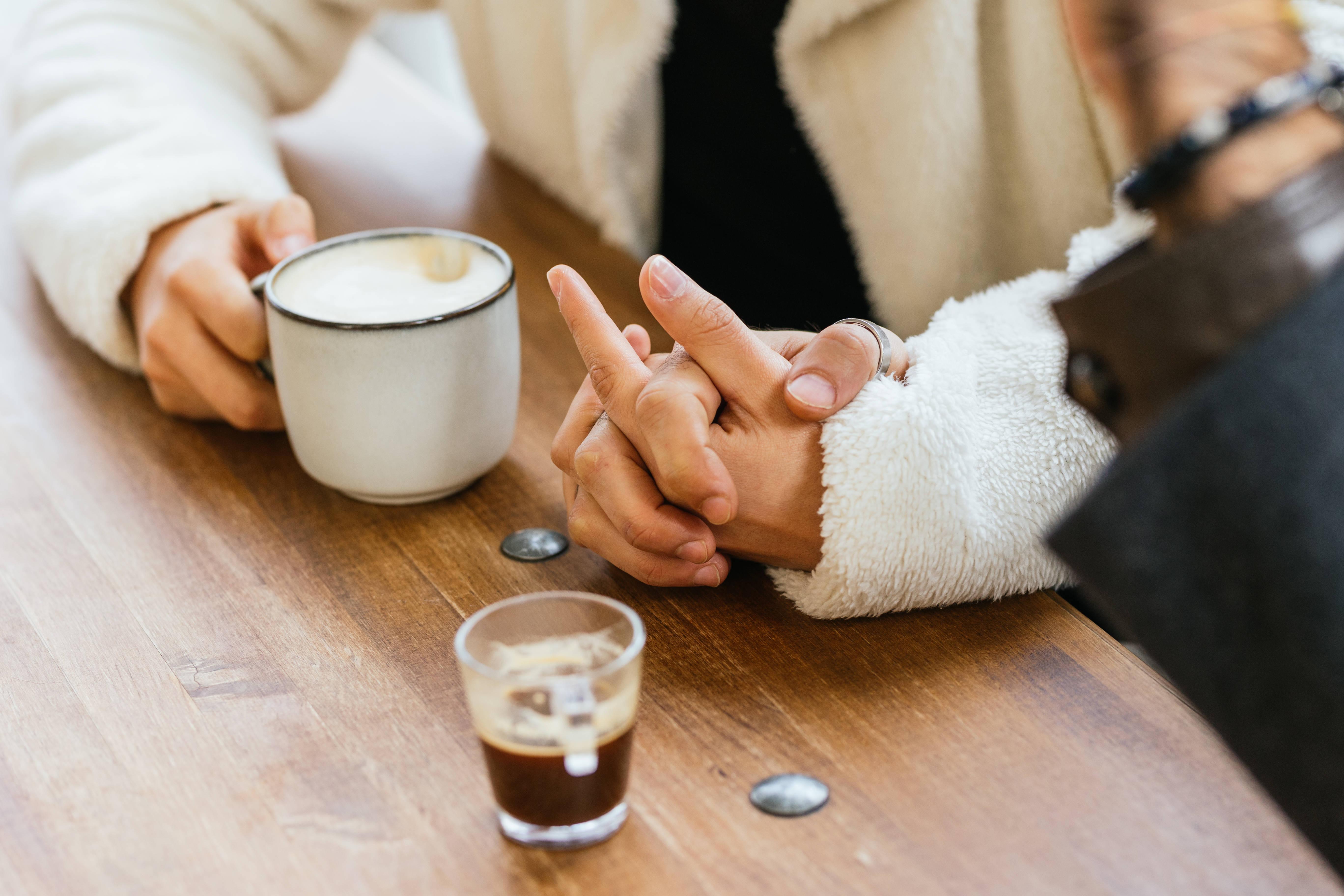 couple-holding-hands-while-enjoying-a-cup-of-coffe-2025-01-09-02-07-11-utc