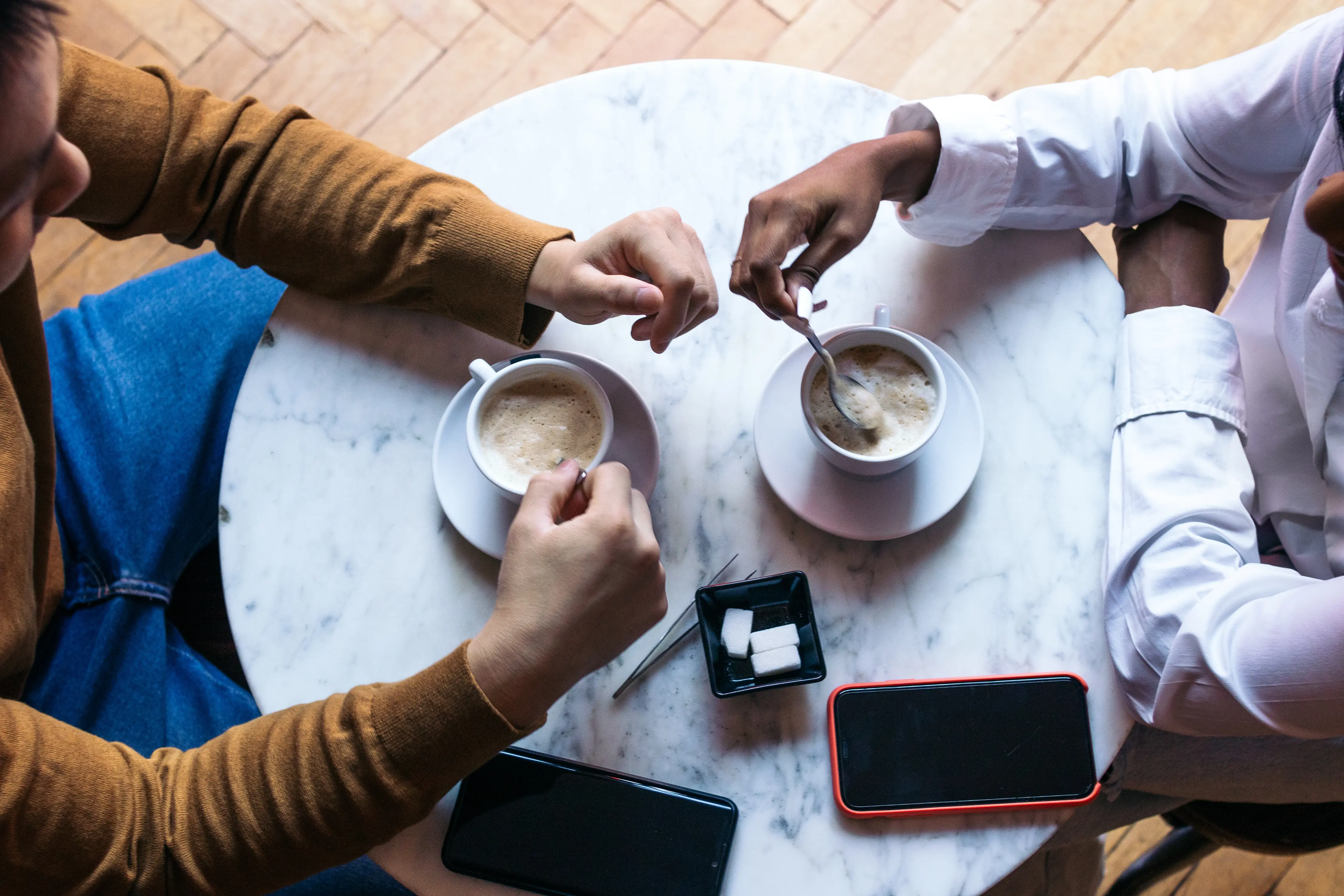 overhead-shot-of-two-people-on-a-date-drinking-cof-2025-03-23-18-42-16-utc