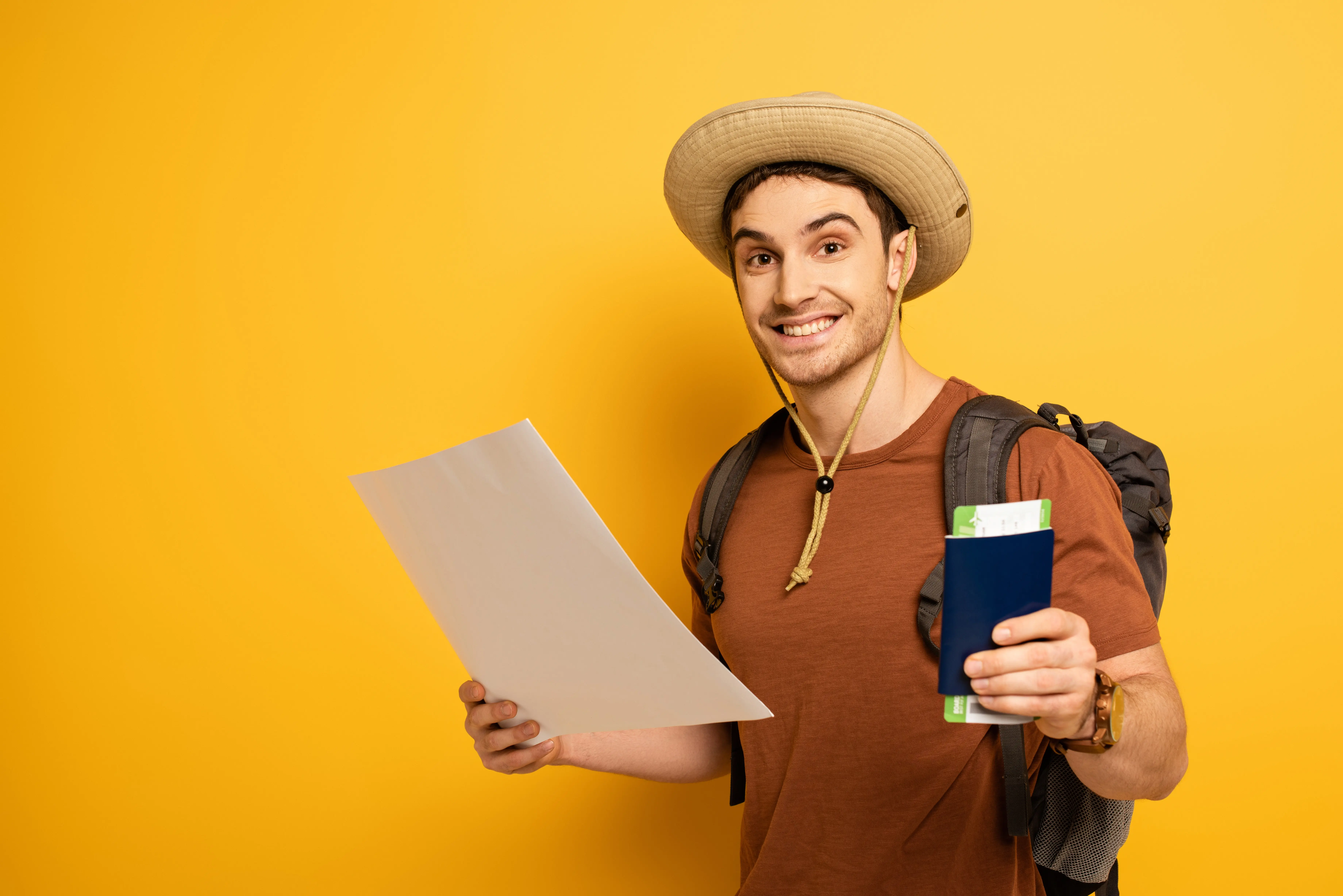 smiling-tourist-in-hat-with-backpack-holding-passp-2024-11-15-16-26-57-utc