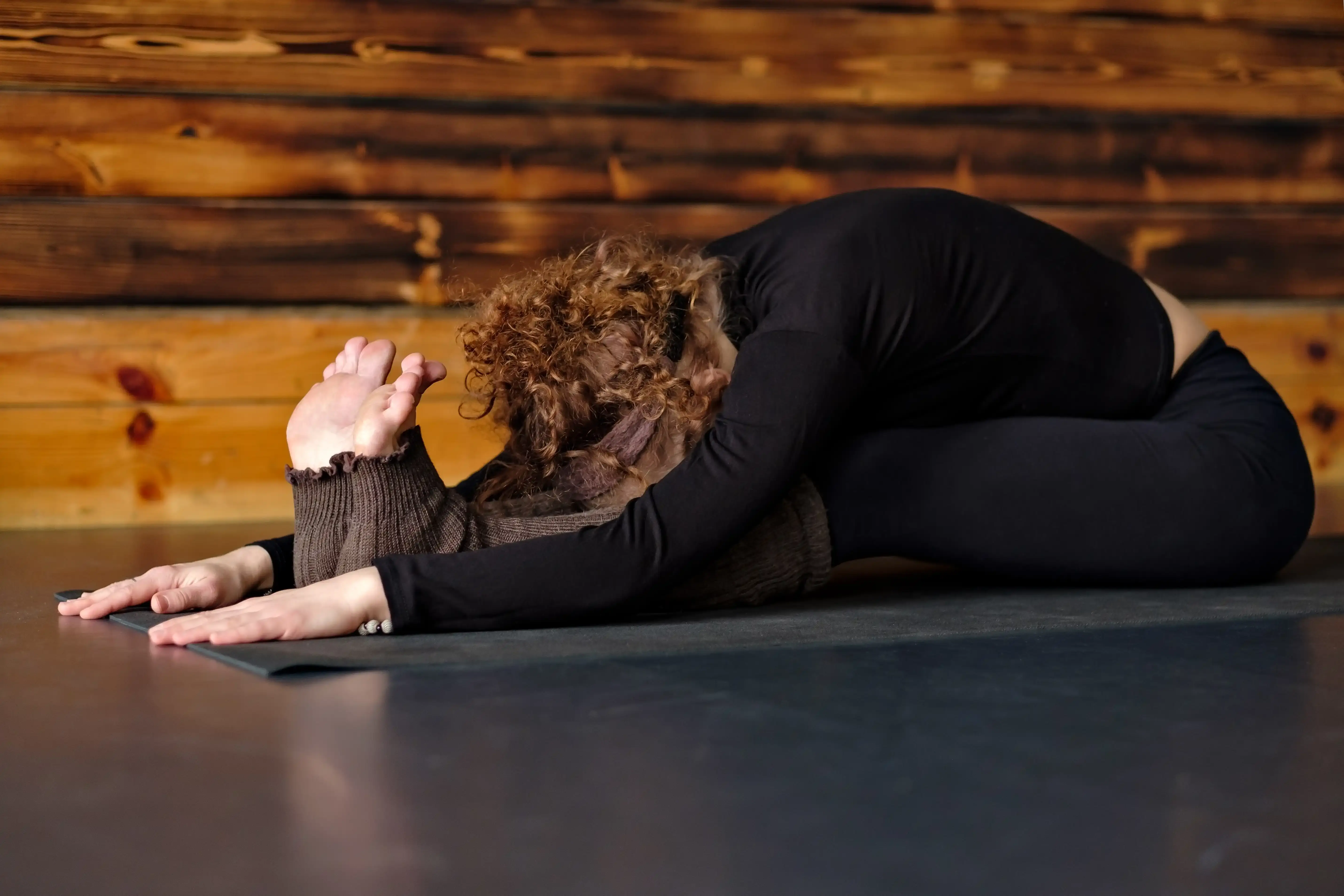 woman-practicing-yoga-stretching-in-seated-forward-2025-01-10-13-38-28-utc