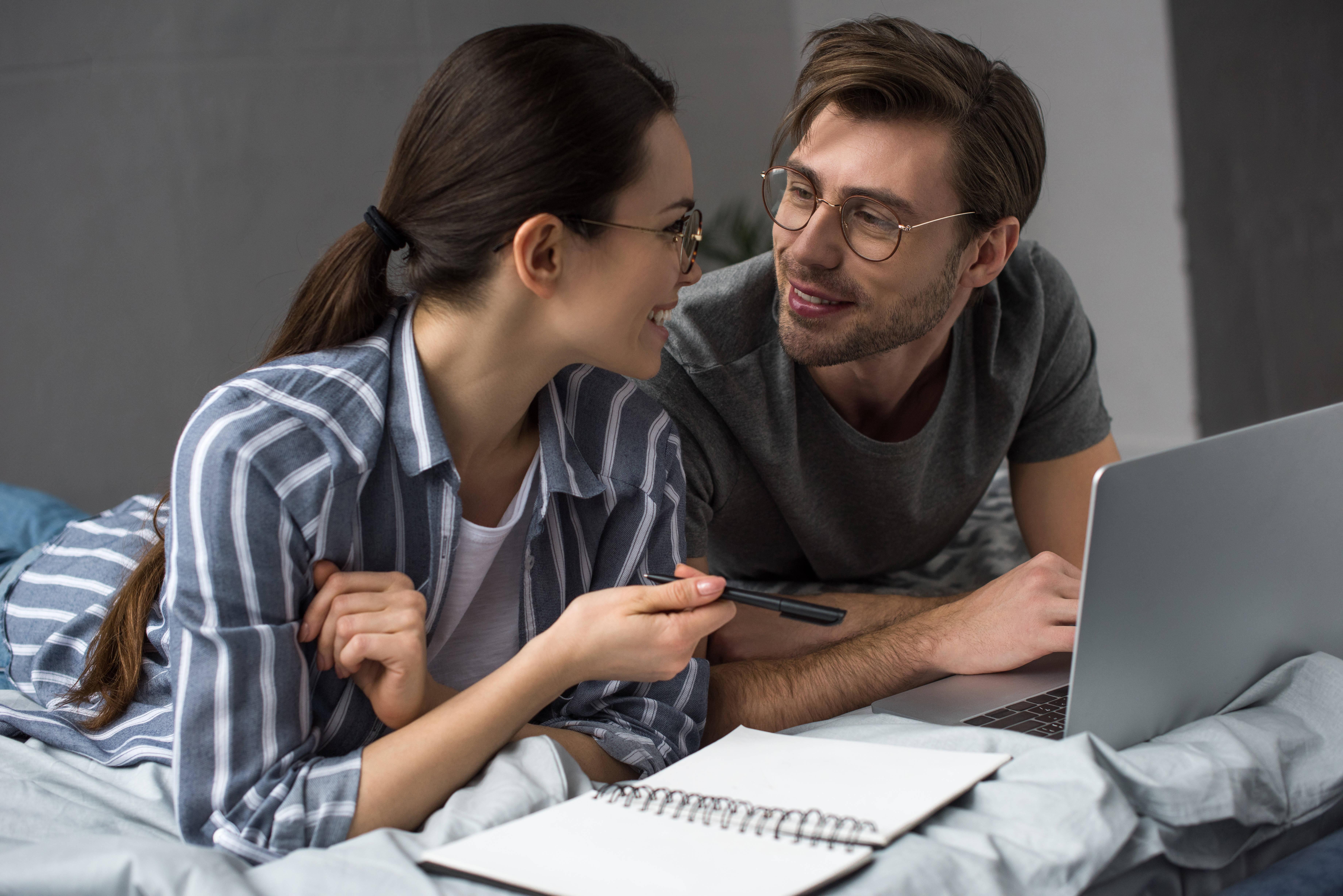 young-couple-writing-in-notepad-and-working-on-lap-2024-11-18-16-48-04-utc
